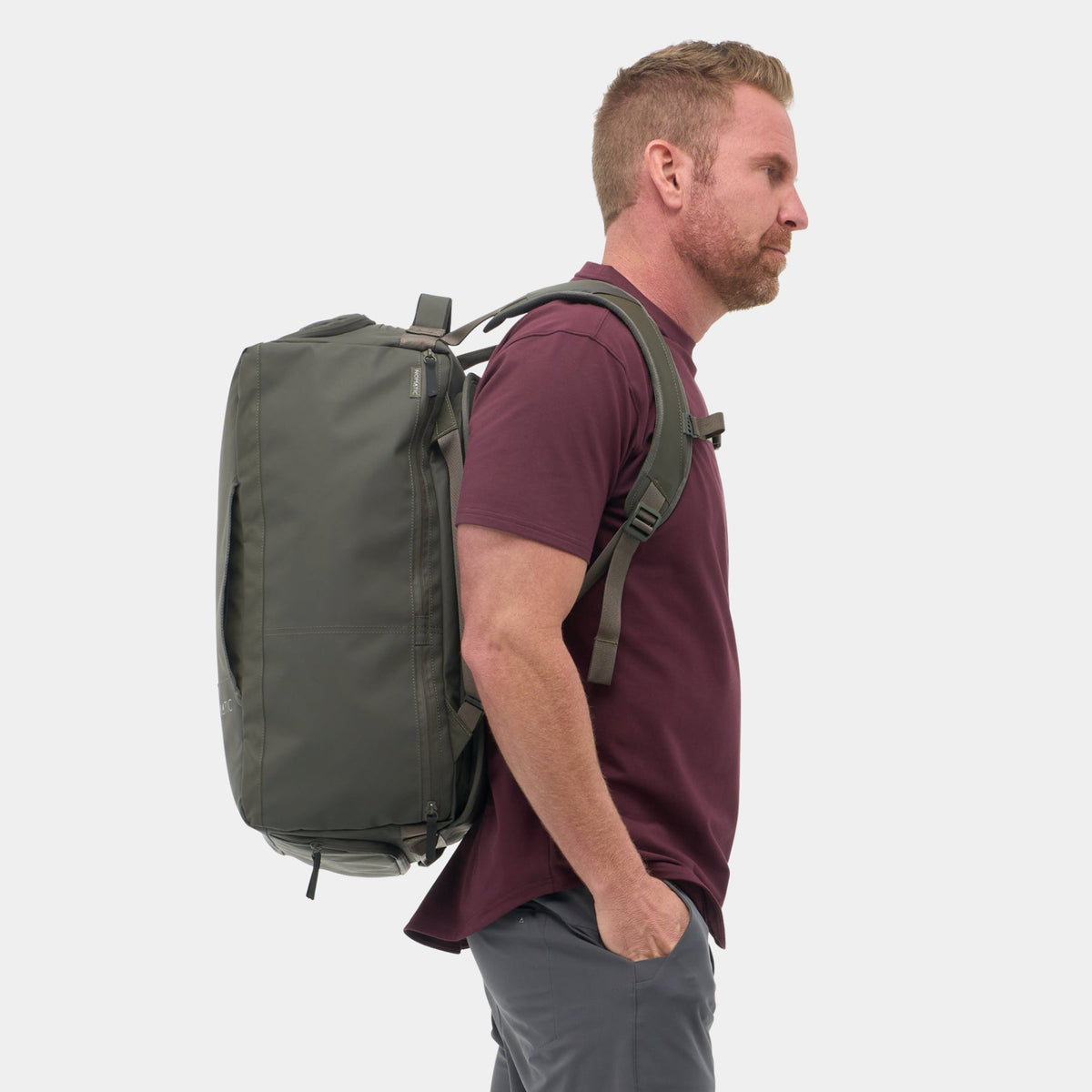 Traveler wearing NOMATIC Travel Bag 40L in olive